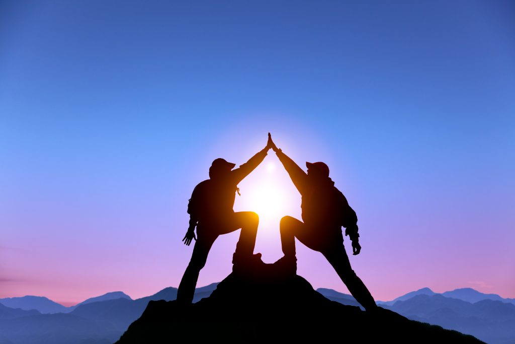 The Silhouette of two man with success gesture standing on the t